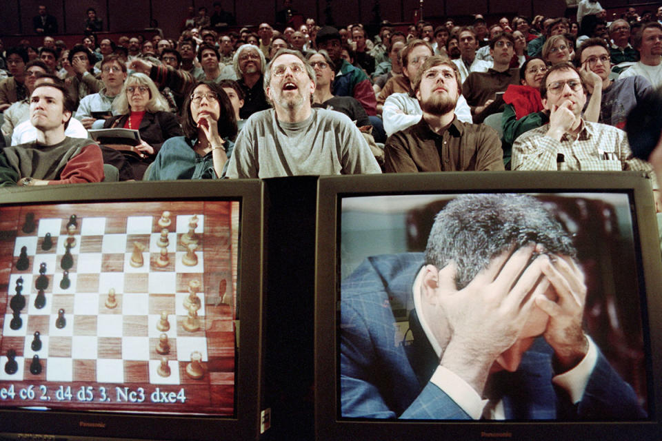 Chess enthusiasts watch World Chess champion Garry Kasparov on a television monitor as he holds his head in his hands at the start of the sixth and final match May 11, 1997 against IBM’s Deep Blue computer in New York. Kasparov lost this match in just 19 moves. (Stan Honda/Getty)