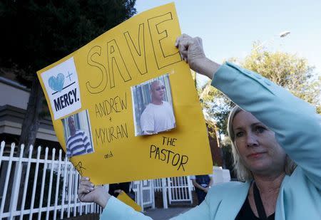 A woman holds a banner calling for a halt to the planned execution of two convicted Australian drug traffickers on death row in Indonesia, outside the Indonesian consulate in Sydney, Australia, April 27, 2015. REUTERS/Jason Reed