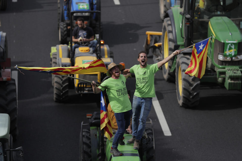 Protesters ride on tractors as they enter the city on the fifth day of protests over the conviction of a dozen Catalan independence leaders in Barcelona, Spain, Friday, Oct. 18, 2019. Various flights into and out of the region are cancelled Friday due to a general strike called by pro-independence unions and five marches of tens of thousands from inland towns are expected converge in Barcelona's center on Friday afternoon for a mass protest with students to and workers who are on strike. (AP Photo/Manu Fernandez)