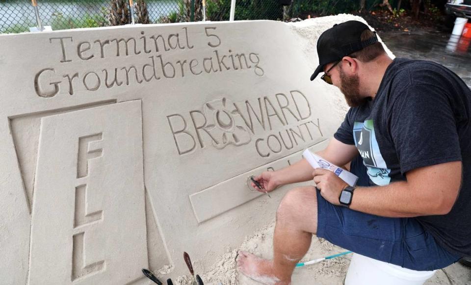 Sand artist Josh Clyde works on a sand sculpture for the groundbreaking of Fort Lauderdale-Hollywood International Airport’s Terminal 5 project on Monday, Oct. 9, 2023. (Carline Jean/South Florida Sun Sentinel)