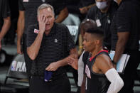 Houston Rockets head coach Mike D'Antoni, left, puts a hand to his face as he speaks with an official standing behind Russell Westbrook, right front, during the second half of an NBA first-round playoff basketball game against the Oklahoma City Thunder in Lake Buena Vista, Fla., Wednesday, Sept. 2, 2020. (AP Photo/Mark J. Terrill)