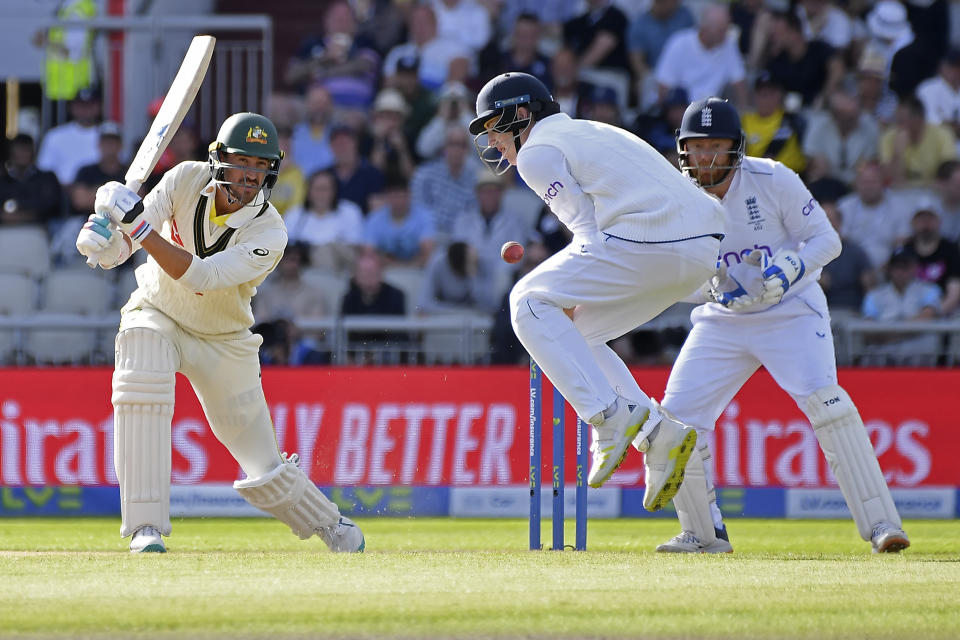 England's Harry Brook, center, tries to stop the ball after a shot played by Australia's Mitchell Starc, left, during the first day of the fourth Ashes cricket Test match between England and Australia at Old Trafford in Manchester, England, Wednesday, July 19, 2023. (AP Photo/Rui Vieira)