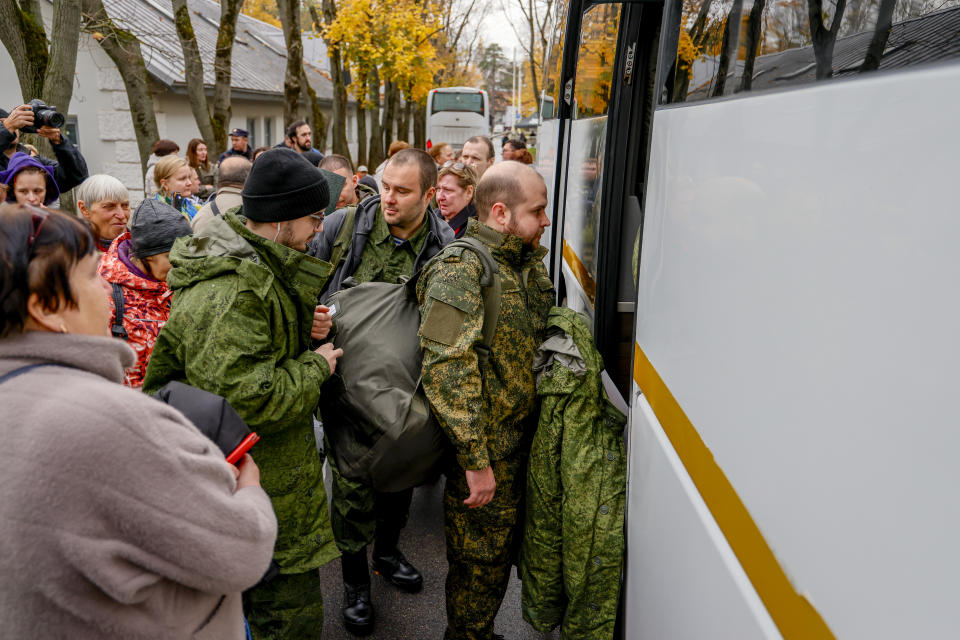 Russian recruits outside a military processing center say goodbye to their families.