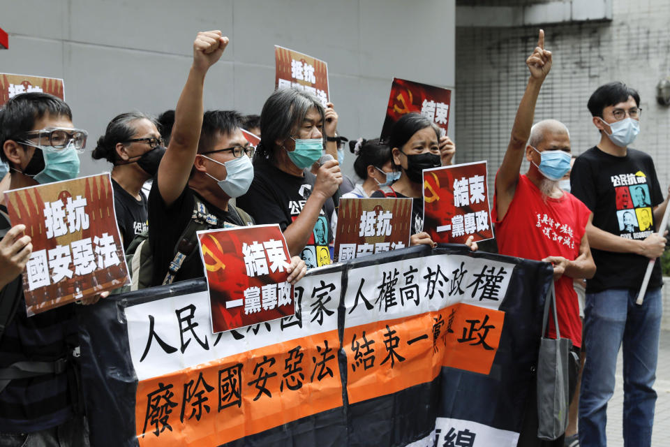 Pro-democracy Leung Kwok-hung, center, and others protesters shout slogans " Stop One Party Rolling" before they march toward the flag raising ceremony marking the anniversary of the Hong Kong handover to China in Hong Kong, Wednesday, July 1, 2020. Hong Kong marked the 23rd anniversary of its handover to China in 1997, one day after China enacted a national security law that cracks down on protests in the territory. (AP Photo/Vincent Yu)