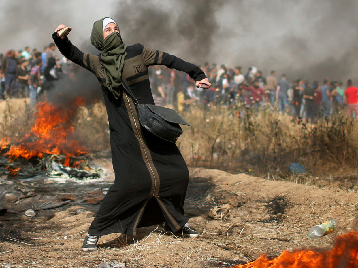 A girl hurls stones during clashes with Israeli troops at a protest where Palestinians demand the right to return to their homeland, at the Israel-Gaza border: Reuters