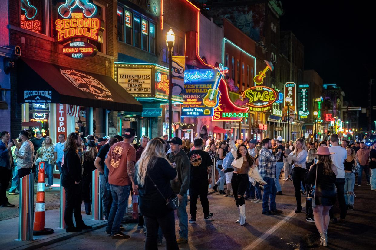 People walk down Lower Broadway in Nashville, Tenn., Friday, April 28, 2023.