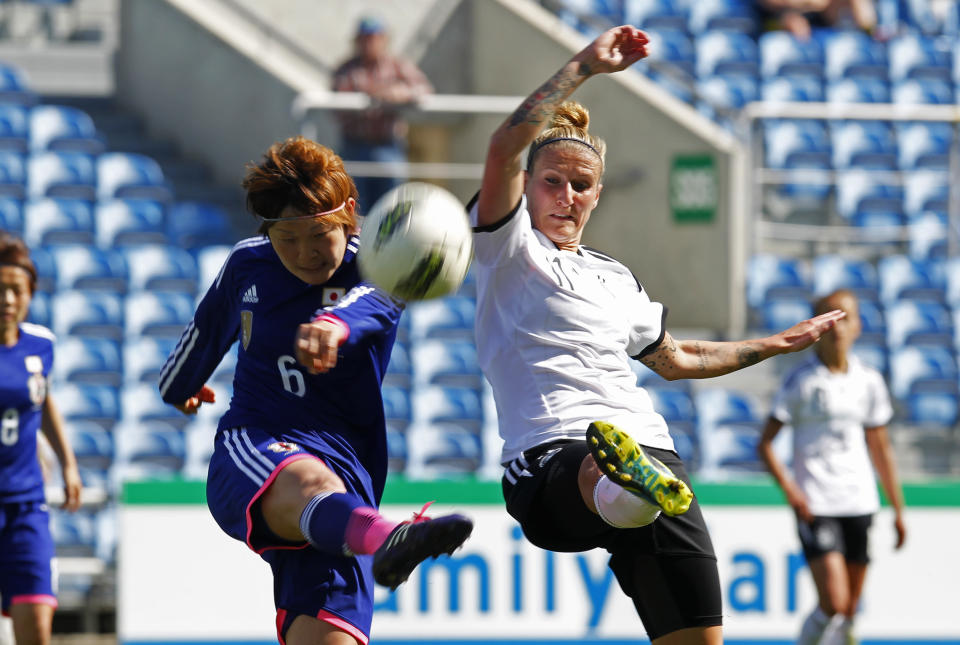 Japan's Sakaguchi Mizuho, left, vies for the ball with Germany's Anja Mittag during the women's soccer Algarve Cup final match between Germany and Japan at the Algarve stadium, outside Faro, southern Portugal, Wednesday, March 12, 2014. (AP Photo/Francisco Seco)