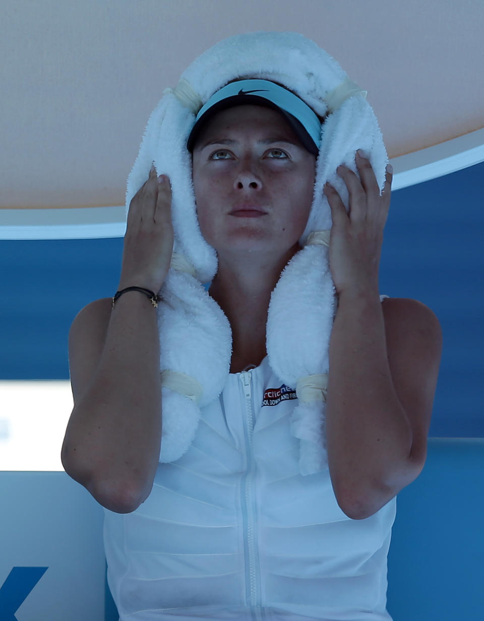 Maria Sharapova of Russia wraps an ice-towel around her head during a break in her second round match against Karin Knapp of Italy at the Australian Open tennis championship in Melbourne, Australia, Thursday, Jan. 16, 2014. Temperatures are expected to top 44cC (112 F) during play today. (AP Photo/Aaron Favila)