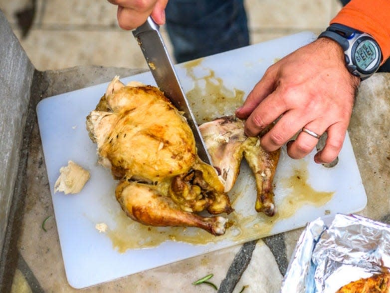 man cutting chicken