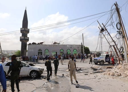 Somali security officers secure the scene of a suicide car explosion at a checkpoint in Mogadishu