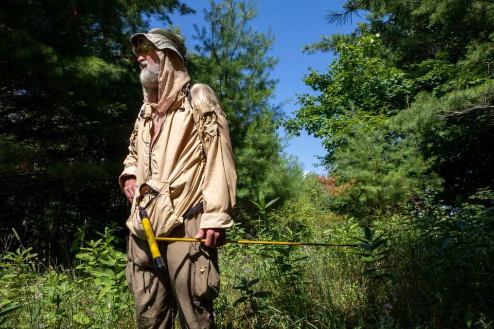 Retired Michigan State Police forensic investigator Mike Neiger of Michigan Back Country Search and Rescue carries a soil probe to test the compaction of the soil as he searches for the remains of Derrick Henagan in McMillan, Mich., Friday, Aug. 3, 2018.