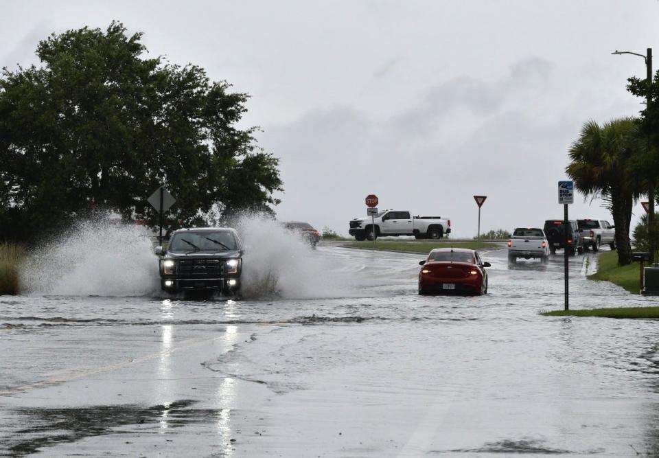 Motorists plow though high water flooding South Ninth Avenue in Pensacola on May 13, 2024.