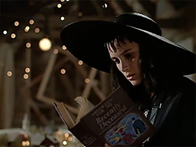 <p>Everett</p> Winona Ryder as Lydia Deetz reading the Handbook for the Recently Deceased