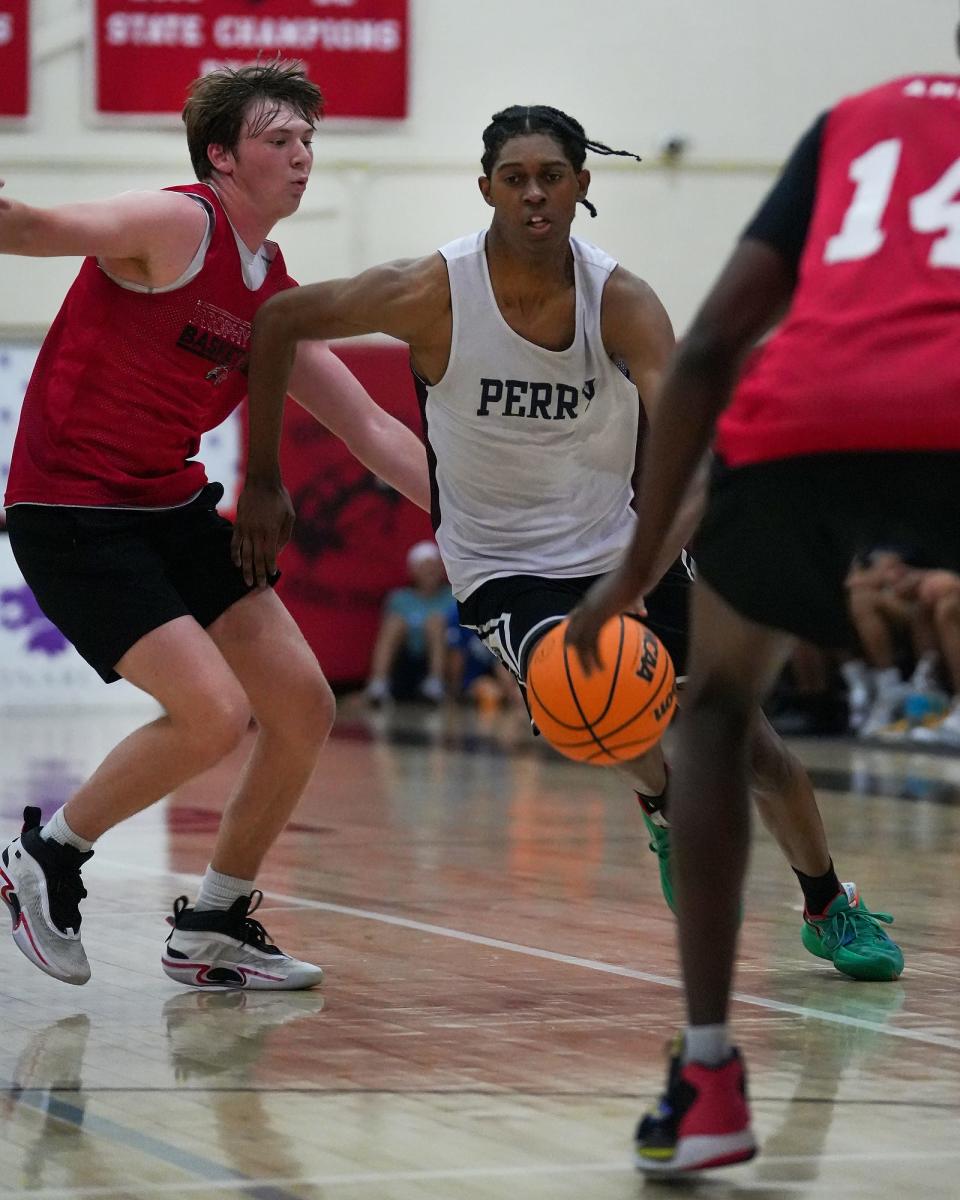 Perry's Cody Williams (9), right, drives to the basket during the championship match between Brophy Prep and Perry High School on Saturday, June 11, 2022, in Phoenix. Perry won the game 64 to 46. The boy's basketball tournament was put on by Monarch Sports PrimeTime.