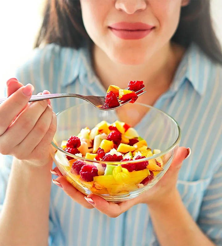 woman eating fresh fruit salad