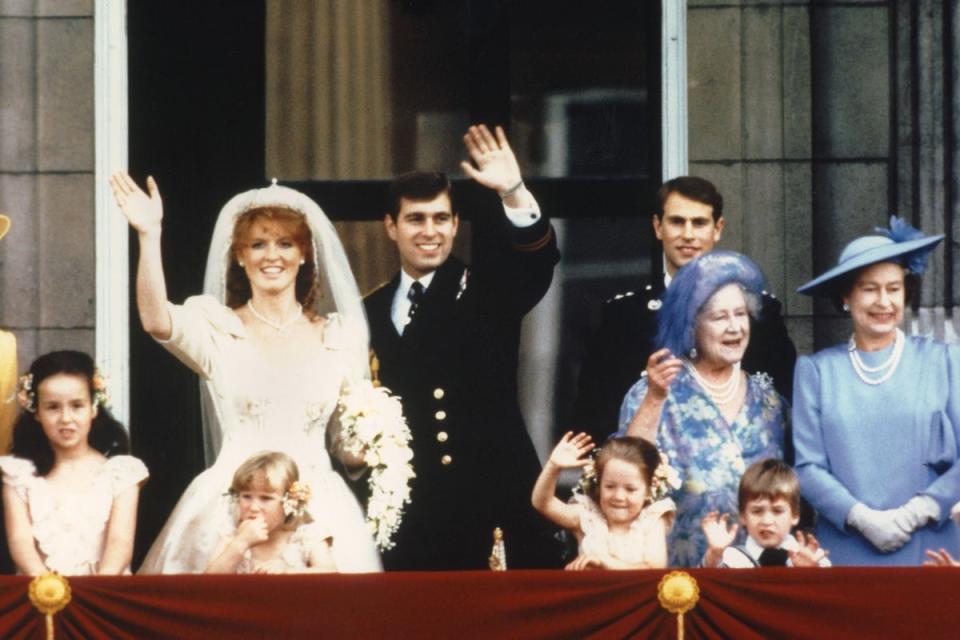 The newly wed Prince Andrew, the Duke of York and his wife Sarah Ferguson, the Duchess of York, wave to crowds on July 23, 1986, from the balcony of Buckingham Palace while Queen Elizabeth II and Queen Mother look on (AFP/Getty Images)