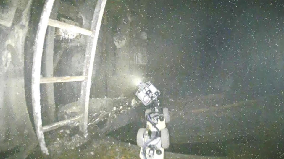 This image taken by a drone and provided by Tokyo Electric Power Company Holdings (TEPCO) shows the snake-shaped robot designed to assist a drone inside the No. 1 reactor as a drone probes inside of the worst-hit reactor at the wrecked Fukushima Daiichi nuclear power plant in Okuma town, northeastern Japan, on March 14, 2024. (TEPCO via AP)