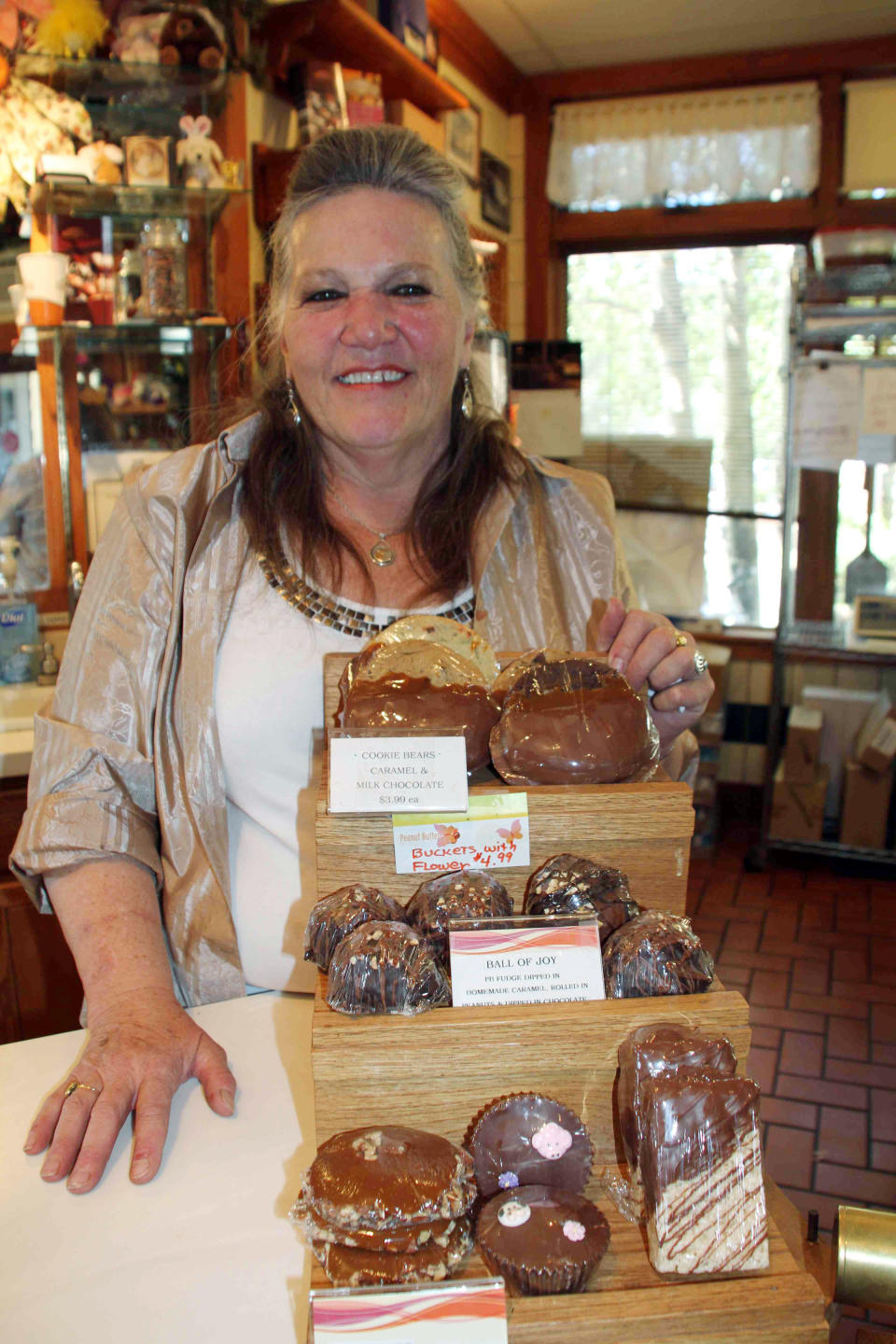 This July 30, 2012 photograph provided by the Estes Park News shows Jo Adams the owner of the Rocky Mountain Chocolate Factory in her store in Estes Park, Colo. A black bear went in and out of the candy store multiple times on July 25, 2012. He used the front door and didn’t break a thing. He did, however, steal some treats. (AP Photo/Estes Park News, Kris Hazelton)