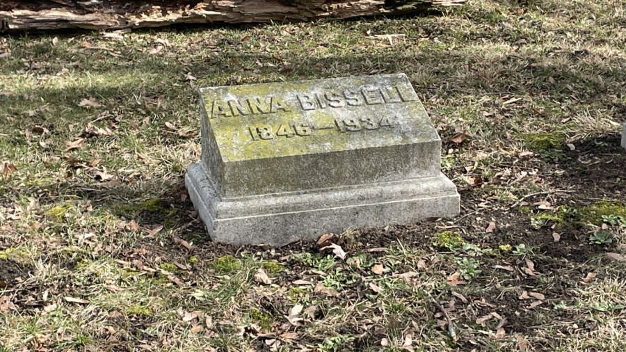 Lichen grows over Anna Bissell's simple headstone that reads "Anna Bissell 1846-1934."