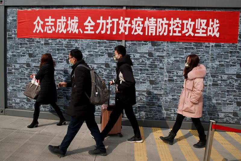 People coming from the Hubei province walk into Jiujiang after passing through a checkpoint at the Jiujiang Yangtze River Bridge