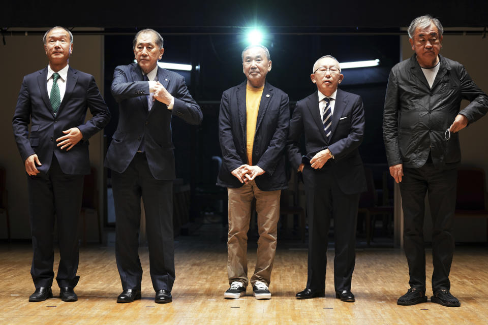 Japanese novelist Haruki Murakami, center, Chairman, President and CEO, UNIQLO CO., LTD. Tadashi Yanai, second right, and Kengo Kuma, right, the architect behind the Olympic stadium, and other university officials pose for media during a press conference on the university's new international house of literature as known as The Haruki Murakami Library" at the Waseda University Wednesday, Sept. 22, 2021 in Tokyo. (AP Photo/Eugene Hoshiko)