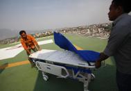 Hospital staff get ready to receive the injured from an avalanche, on helipad of Grandy hospital, in Katmandu, Nepal, Friday, April 18, 2014. An avalanche swept down a climbing route on Mount Everest early Friday, killing at least 12 Nepalese guides and leaving three missing in the deadliest disaster on the world's highest peak. (AP Photo/Niranjan Shrestha)