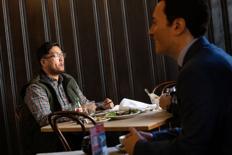 A diner enjoys a meal as Madame Tussauds's wax figure of Jimmy Fallon sits at an empty table at Peter Luger Steak House in Brooklyn, New York