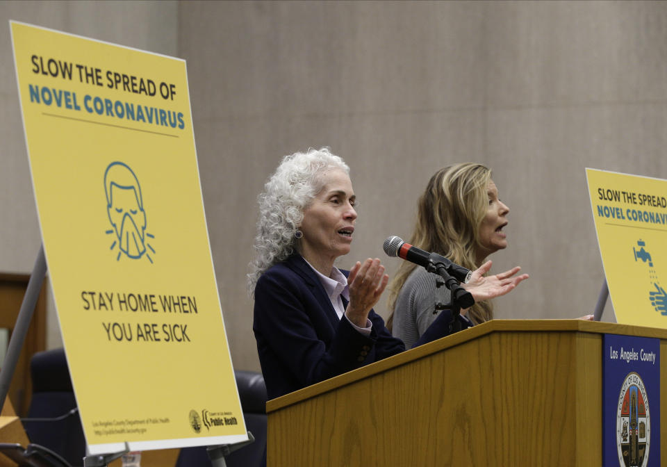 Los Angeles County Public Health Director Barbara Ferrer, left, takes questions at a news conference in Los Angeles Thursday, March 12, 2020. At right is Niago Wilson, a sign language interpreter. Ferrer confirmed that a woman with underlying health conditions has died of the coronavirus in the most populous county in the U.S. It's the first death from the virus in the Los Angeles County. (AP Photo/Damian Dovarganes)