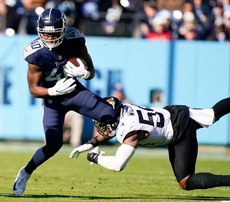 Tennessee Titans running back Dontrell Hilliard (40) tries to evade Jacksonville Jaguars middle linebacker Damien Wilson (54) during the second quarter Nissan Stadium Sunday, Dec. 12, 2021 in Nashville, Tenn. 