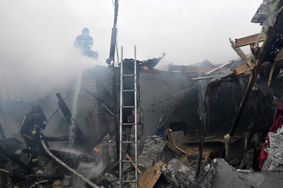 Ukrainian firefighters douse flames in a burning house following Russian shelling in the city of Kherson, on January 29 (AFP via Getty Images)