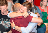 <p>England fans in McCooley’s Sports Bar in Liverpool hug after their side’s win at the World Cup.<br>(Picture: SWNS) </p>