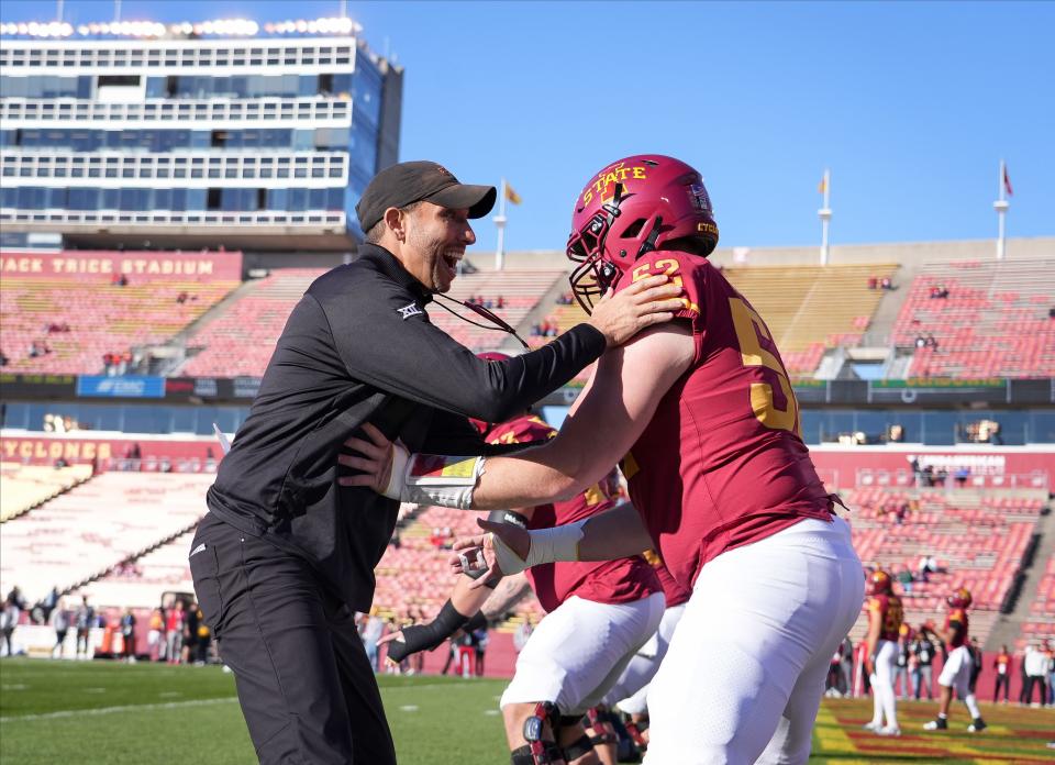 Matt Campbell consults with center Trevor Downing, the anchor of a line that will be trying to open holes for now-healthy running backs on Saturday.