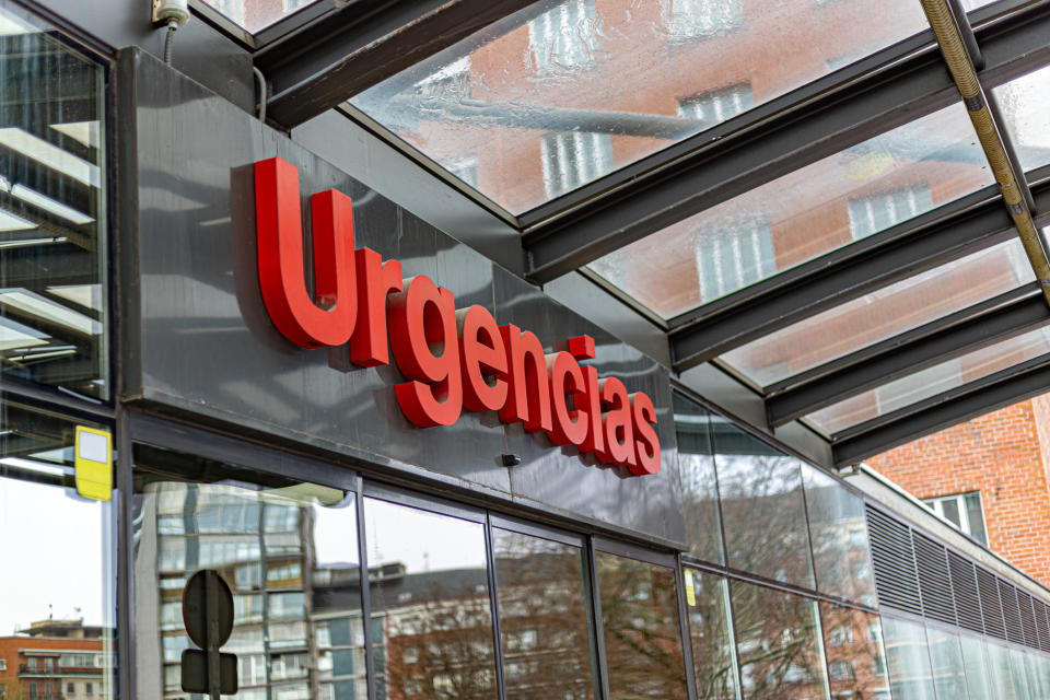 Entrance to a hospital emergency department in a Spanish-speaking area with the sign "Urgencias" above the door