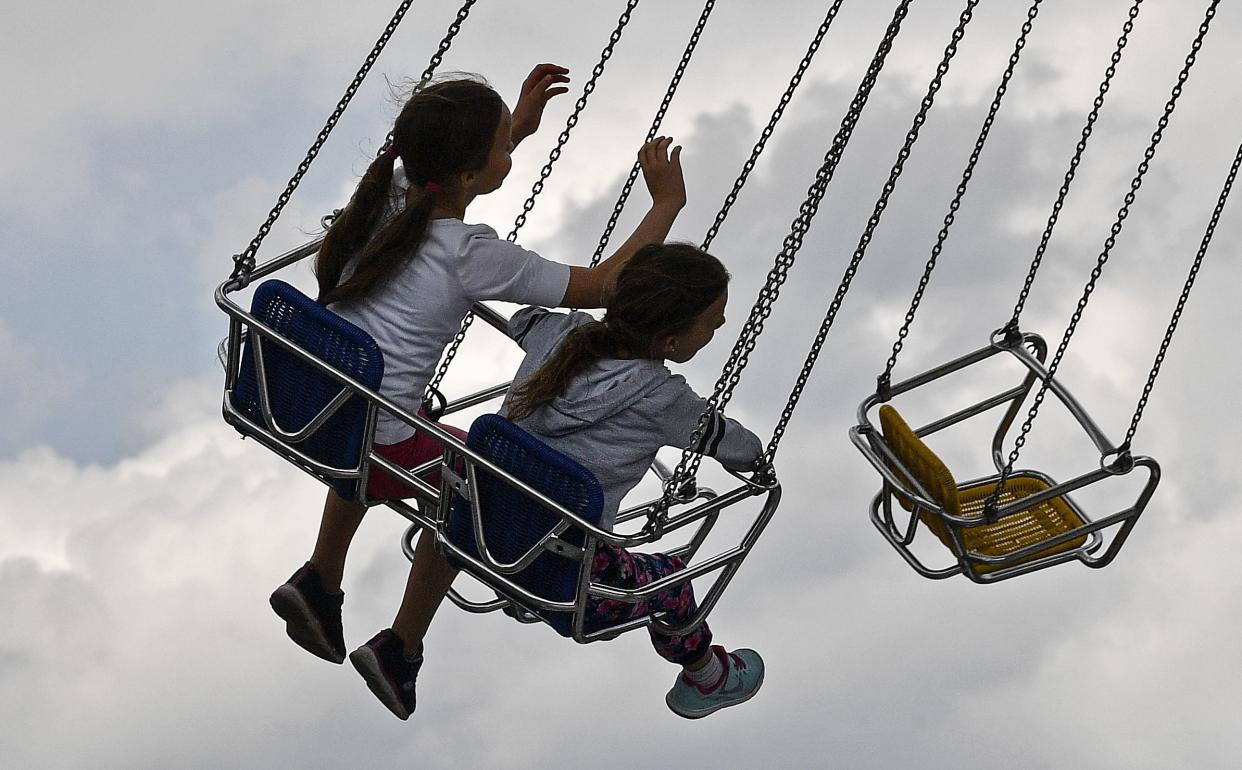 Children enjoy a swing ride at the pop-up funfair "Duesselland" at the fairgrounds in Duesseldorf, Germany on Wednesday, July 15, 2020. Many trade shows had to be cancelled because of the COVID-19 outbreak, so the exhibition grounds organized the first pop-up amusement park under strong public health restrictions instead.