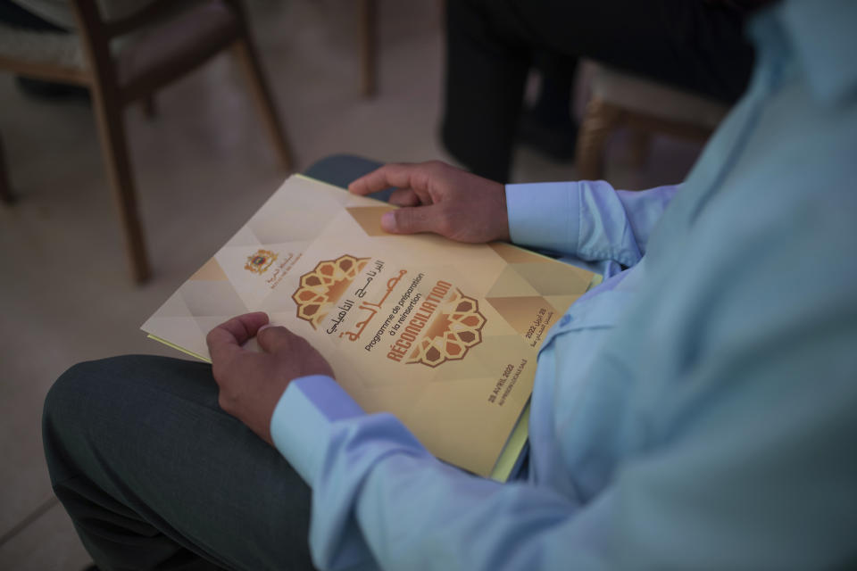 An inmate convicted on terror charges holds a notebook during a ceremony that's part of a reconciliation program to rehabilitate and de-radicalize them, in Sale, Morocco, Thursday, April 28, 2022. Since 2017, Morocco's prison authority has been offering “de-radicalization” training to former Islamic State fighters and others convicted of terrorism offenses. (AP Photo/Mosa'ab Elshamy)