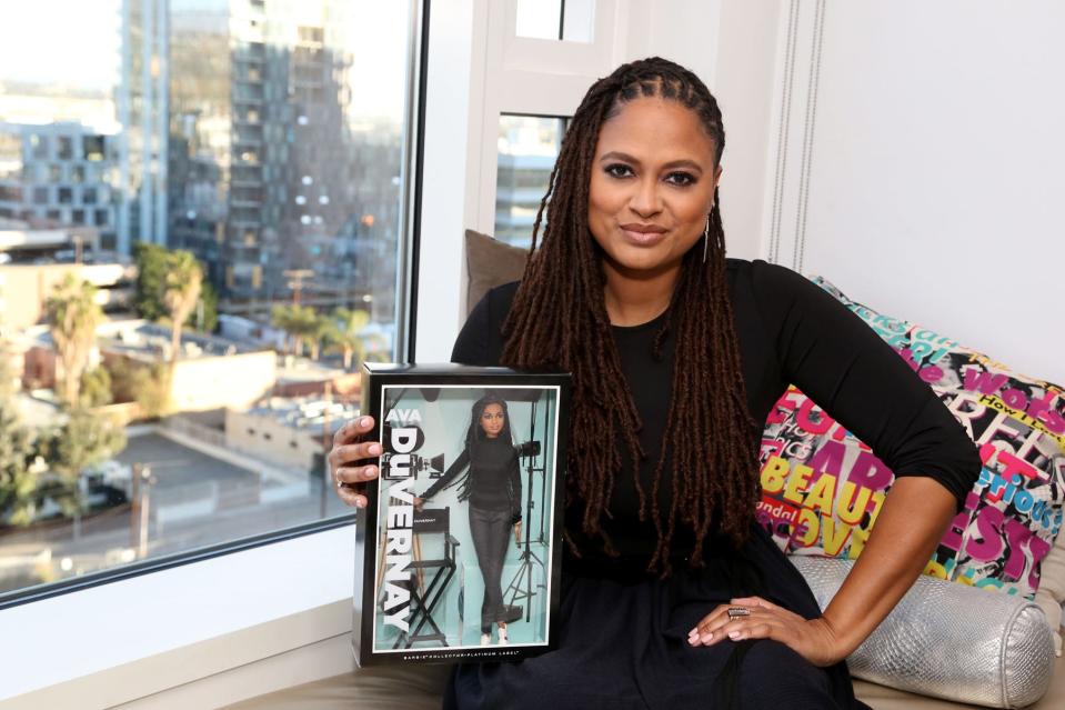 Ava DuVernay holds a Barbie version of herself