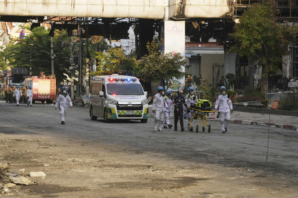 Cambodian and Thai rescue experts walk through a ruined building at the scene of a massive fire at a Cambodian hotel casino in Poipet, west of Phnom Penh, Cambodia, Friday, Dec. 30, 2022. The fire at the Grand Diamond City casino and hotel Thursday injured over 60 people and killed more than a dozen, a number that officials warned would rise after the search for bodies resumes Friday. (AP Photo/Heng Sinith)