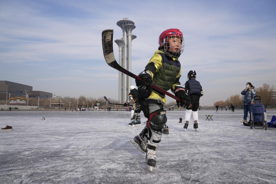 A child practices ice hockey near the Beijing Olympics Tower in Beijing, China, Tuesday, Jan. 18, 2022. The Beijing Winter Olympics is tapping into and encouraging growing interest among Chinese in skiing, skating, hockey and other previously unfamiliar winter sports. It's also creating new business opportunities (AP Photo/Ng Han Guan)