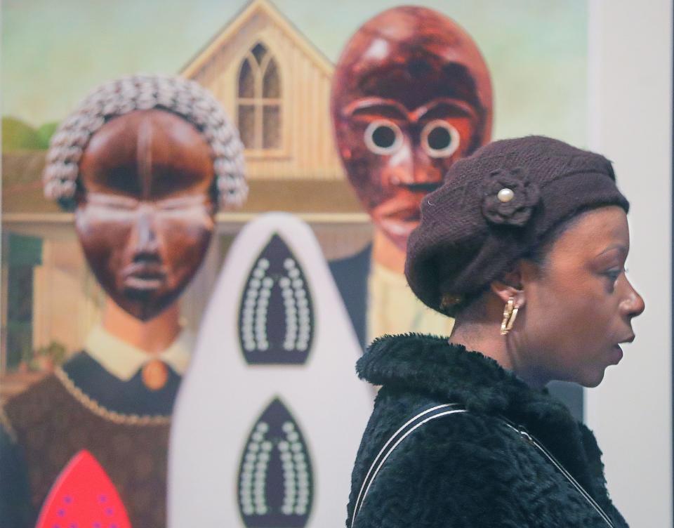 Tameka Ellington talks about artist Willie Cole's "American Domestic" artwork at the Akron Art Museum on Monday. Ellington is the guest curator of "RETOLD: African American Art and Folklore."