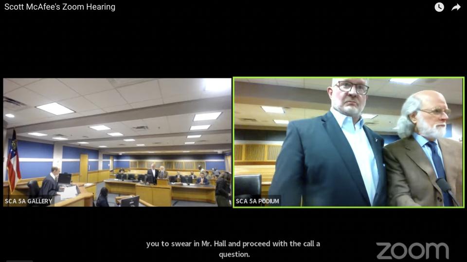 In this image made from video from Judge Scott McAfee's virtual Zoom hearing, Scott Graham Hall, right frame, second from right, stands with his attorney Jeff Weiner, far right, in Superior Court of Fulton County before Judge McAfee, left frame, in Courtroom 5A on Friday, Sept. 29, 2023, in Atlanta. Hall, a bail bondsman charged alongside former President Donald Trump and 17 others in the Georgia election interference case, pleaded guilty to misdemeanor charges on Friday, becoming the first defendant to accept a plea deal with prosecutors. (USA Today via AP, Pool)