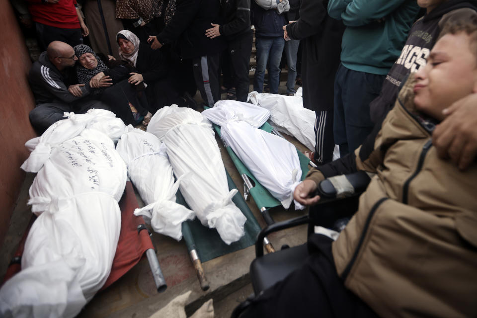 Palestinians mourn relatives killed in the Israeli bombardment of the Gaza Strip outside a morgue in Khan Younis on Sunday, Dec. 10, 2023. (AP Photo/Mohammed Dahman)