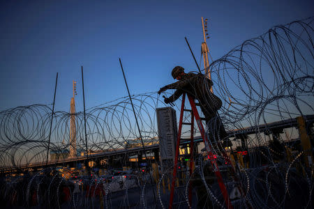 FILE PHOTO: A United States Marine fortifies concertina wire along the San Ysidro Port of Entry border crossing as seen from Tijuana, Mexico November 20, 2018. REUTERS/Adrees Latif/File Photo