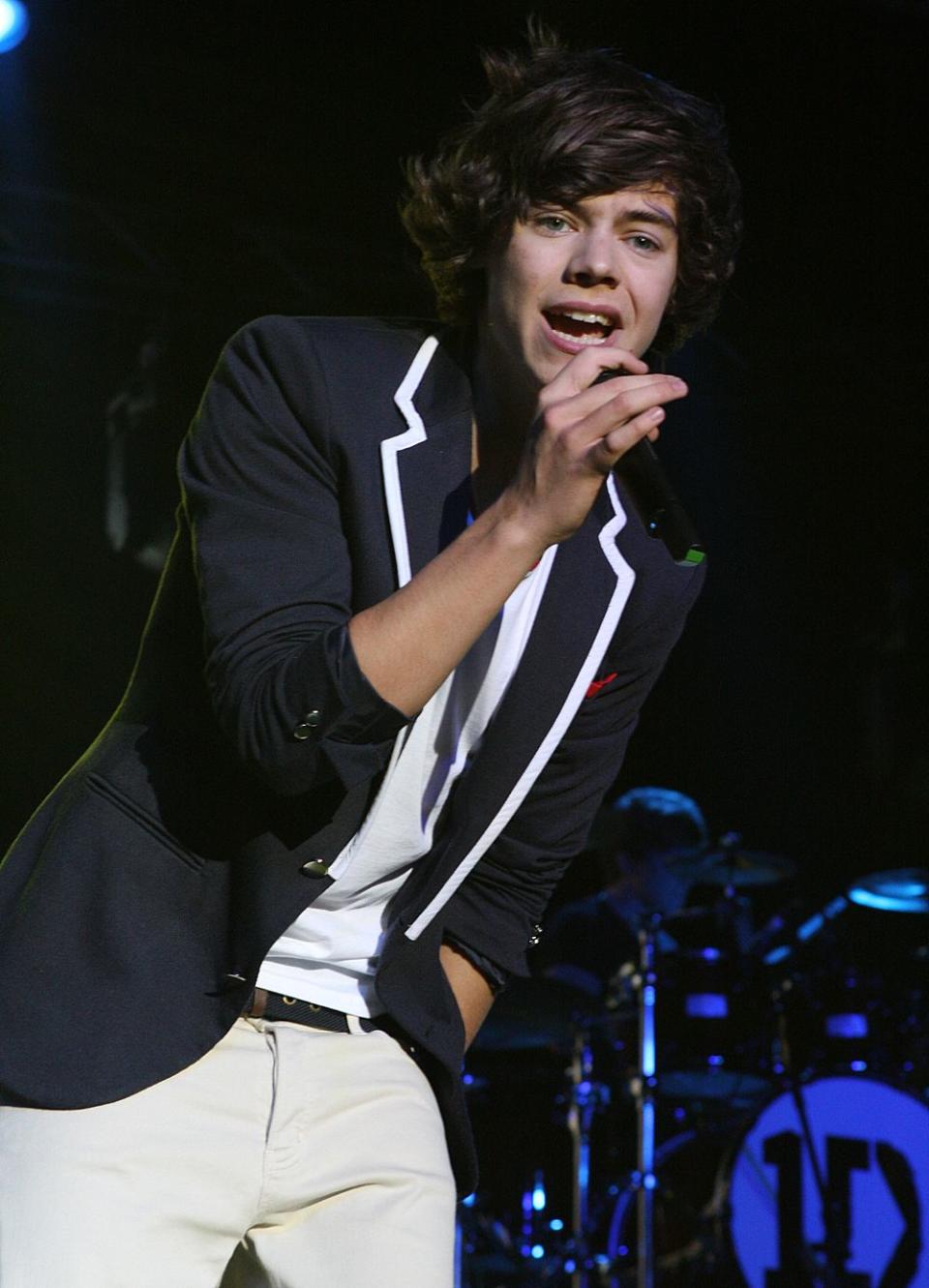 Performing one of his amazing songs, young Harry Styles sports a blue suit-jacket with white edges and white pant to match