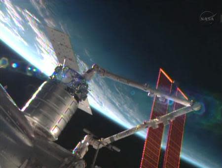 The unmanned U.S. commercial cargo ship Cygnus is seen being attached to the International Space Station in this September 29, 2013 handout still image from video by NASA. REUTERS/NASA TV/Handout via Reuters