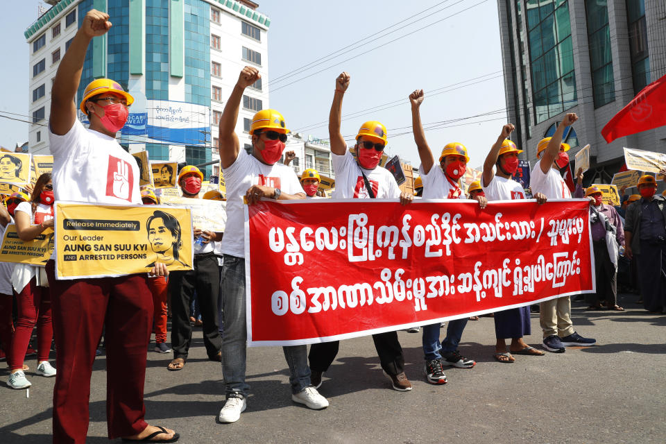 Protesters raise their hands with clenched fists during an anti-coup rally in front of the Myanmar Economic Bank in Mandalay, Myanmar on Monday, Feb. 15, 2021. Myanmar's military leaders extended their detention of Aung San Suu Kyi, whose remand was set to expire on Monday, as protests continued to roil the Southeast Asian country following a military coup earlier this month. (AP Photo)