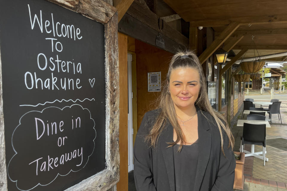 Teresa Mochan, restaurant manager and shareholder at the Osteria restaurant in Ohakune, New Zealand poses for a photo on Sept. 22, 2022. New Zealand's Turoa ski field is usually a white wonderland at this time of year, its deep snowpack supporting its famed spring skiing. But this season it remains a barren moonscape, with tiny patches of snow poking out between vast fields of jagged volcanic boulders. (AP Photo/Nick Perry)