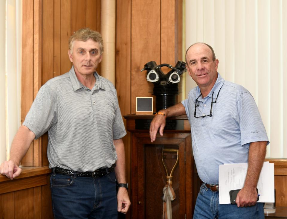 Canton Drop Forge executives John Silvestro, vice president, and Brad Ahbe, president, stand next to a case with the ceremonial shovel used in 1942 to break ground for the factory on Southway Street SW. A forged cylinder housing for an airplane engine is on top of the case.