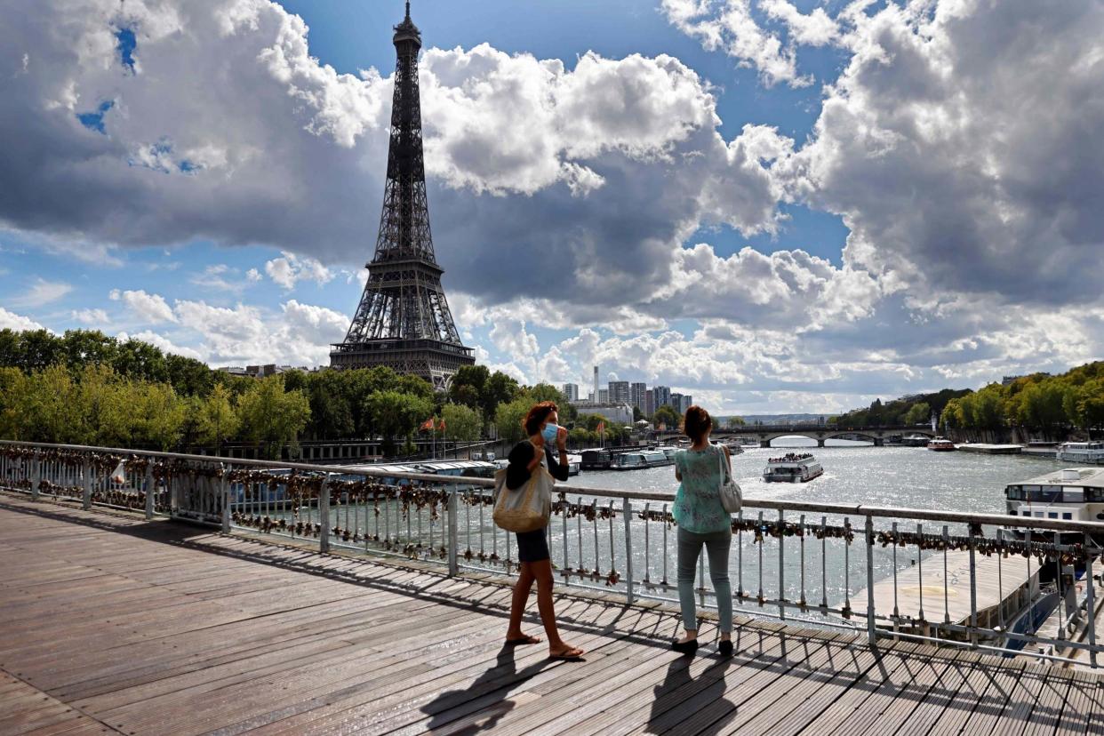 La promenade: masked visitors on a bridge near the Eiffel Tower: AFP via Getty Images