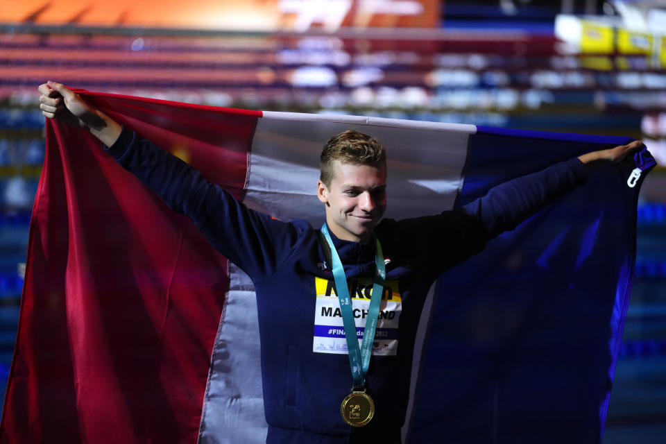 Leon Marchand of France holds a flag and poses with his medal after winning the men's 400m medley final at the 19th FINA World Championships in Budapest, Hungary, Saturday, June 18, 2022. (AP Photo/Petr David Josek)