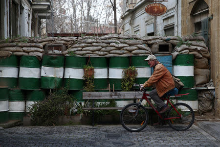 A man rides a bicycle past a barricade outside the U.N. buffer zone in Nicosia, Cyprus February 16, 2017. REUTERS/Yiannis Kourtoglou